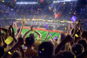 Sporting Events - Large Crowd Cheering Under Stadium Lights While Confetti Flies Through the Air